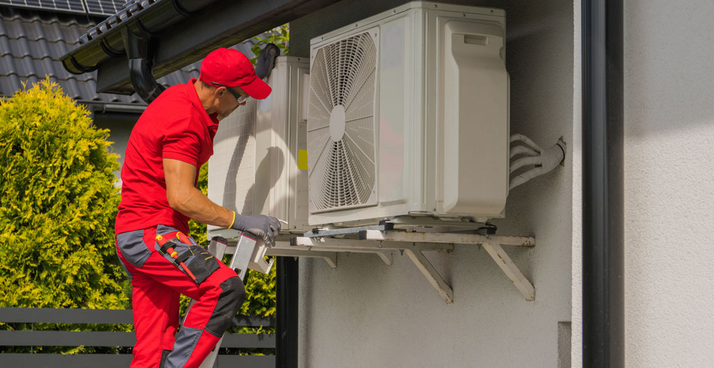 Unité extérieure de pompe à chaleur en fonctionnement avec de la vapeur de condensation visible dans un jardin de maison pavillonnaire moderne